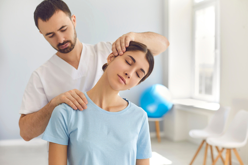 Car accident chiropractor strectching out a woman's neck to help her with a neck injury after a car accident.