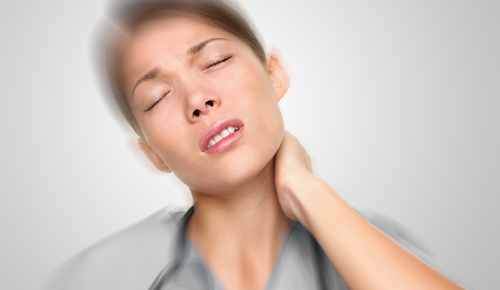 Woman holding her neck in pain due to car accident and now needing whiplash injury treatment.