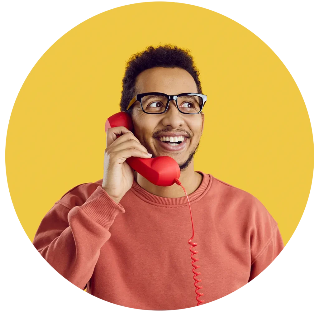 Man smiling while on a red phone