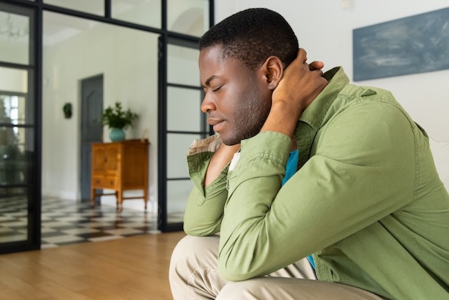 Person experiencing delayed pain from missed car accident injuries at home
